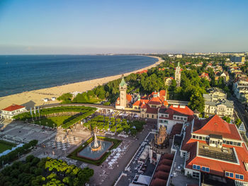 High angle view of buildings by sea against clear sky
