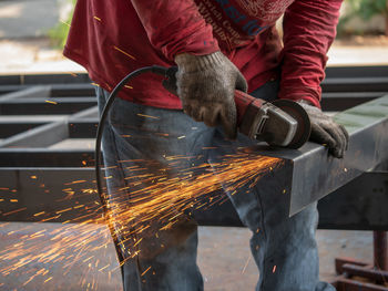 Low angle view of man working on metal