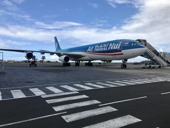 Airplane on runway against sky