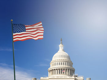 Low angle view of flag against blue sky