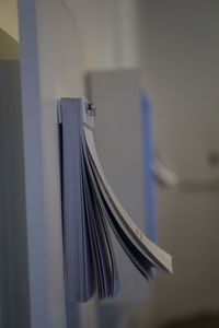 Low angle view of paper hanging against white wall