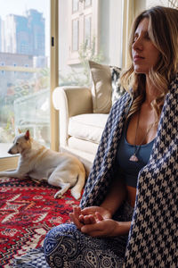 Woman meditating and her dog sitting beside