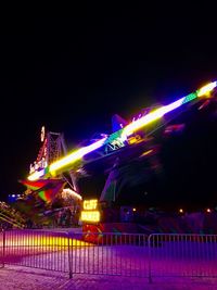 Illuminated ferris wheel at night