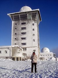 Full length of woman standing on snow against sky