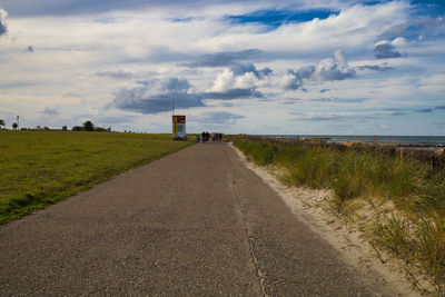 Road amidst land against sky