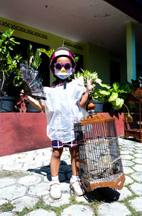 Full length portrait of boy standing in basket