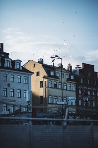 Buildings by river against sky in city