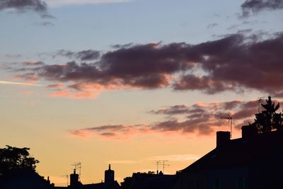 Low angle view of silhouette buildings against sky at sunset
