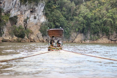 Boat moored on river against trees