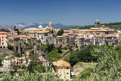 Buildings in town against clear sky