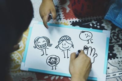 High angle view of hand holding paper on table