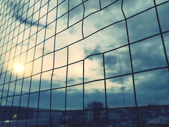 Low angle view of glass building against sky during sunset