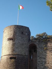 Low angle view of flag against clear blue sky