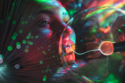 Digital composite image of woman and plasma ball with fiber optics