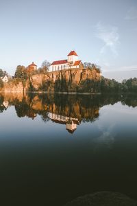 Reflection of building on lake against sky