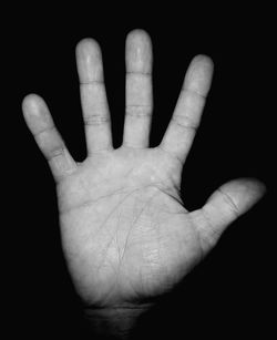 Close-up of human hand against black background