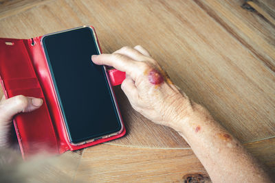 High angle view of man using mobile phone on table