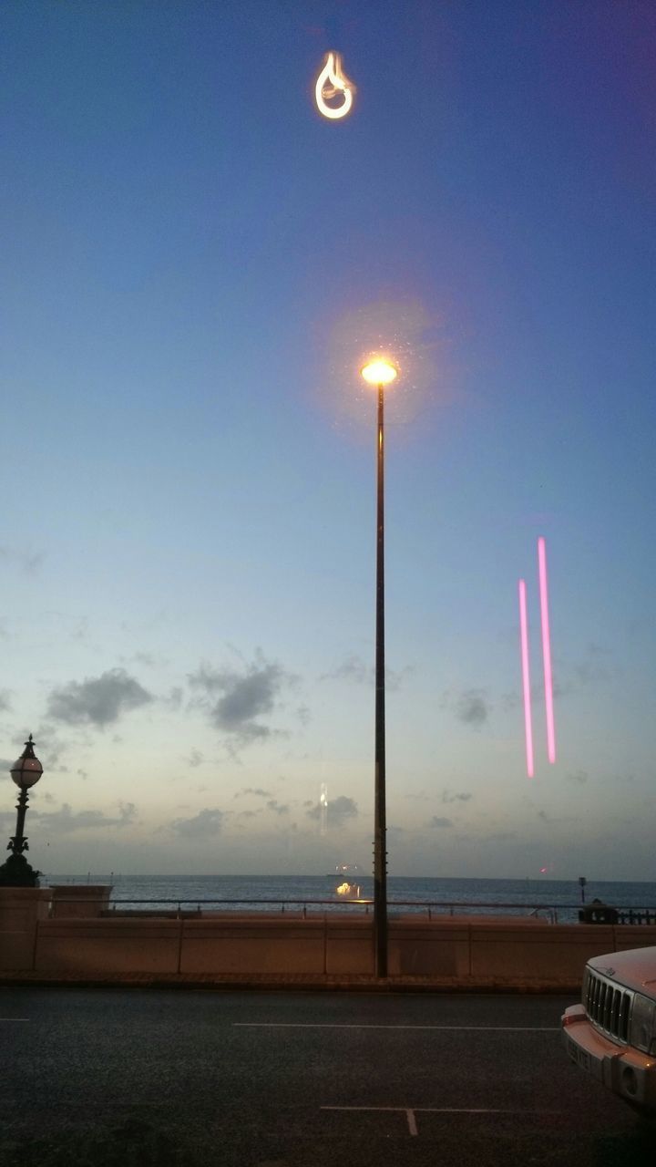 ILLUMINATED BEACH AGAINST SKY AT NIGHT