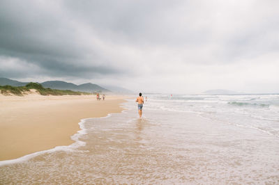 People walking on beach against sky