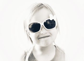 Portrait of boy wearing sunglasses against white background
