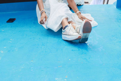 Low section of woman sitting in swimming pool