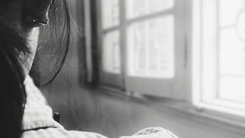 Cropped image of woman by window at home