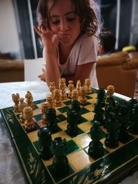 Girl playing chess at home