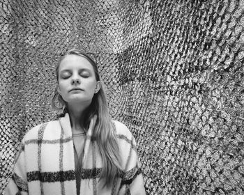 Portrait of woman standing against wall