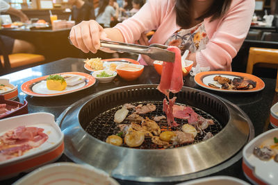 Midsection of woman eating food at restaurant