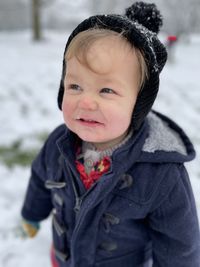 Boy playing with snow during winter outdoors