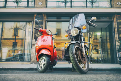 Motor scooter on road by building