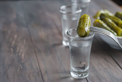 Close-up of pickled cucumbers in bowl on wooden table