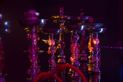 Close-up of illuminated hookahs on table at nightclub