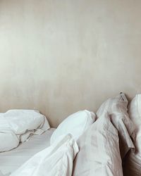 View of pillows on bed against wall