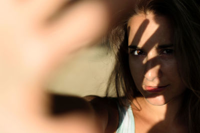 Close-up portrait of young woman gesturing at home