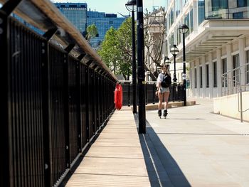 Rear view of man walking on footbridge