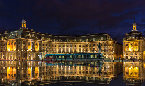 Reflection of illuminated buildings in city at night