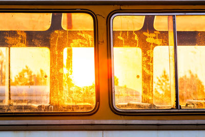 Old bus seen through window with golden sunlight behind
