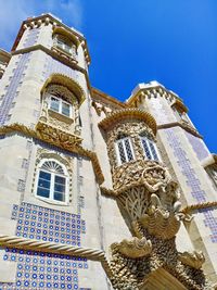 Low angle view of ornate building against blue sky