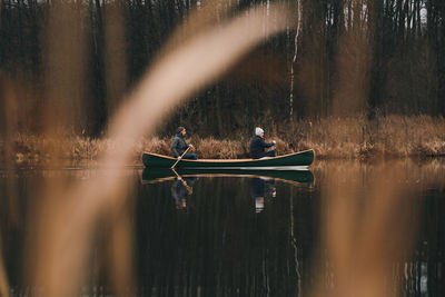 Reflection of man swimming in lake