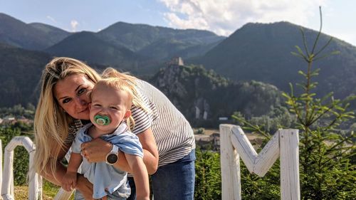 Portrait of smiling mother with son against mountain