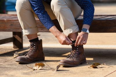 Low section of man tying shoelaces