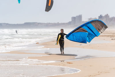 Man holding umbrella on beach