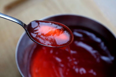 High angle view of preserves on spoon over container