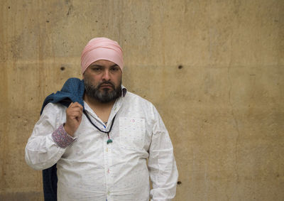 Portrait of man standing by wall