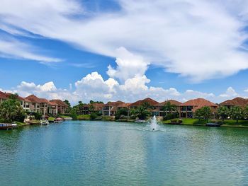 Scenic view of river by buildings against sky