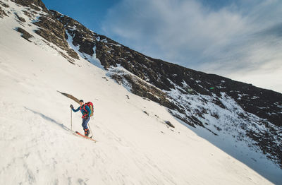 Person skiing on snowcapped mountain against sky