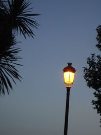 Low angle view of illuminated street light against sky