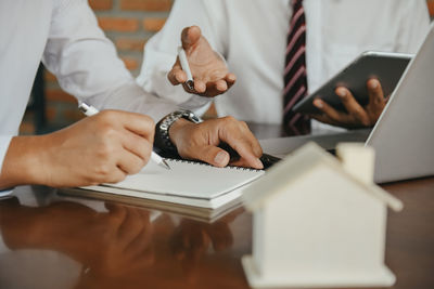 Midsection of businessman holding book