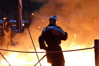 Rear view of man working at night